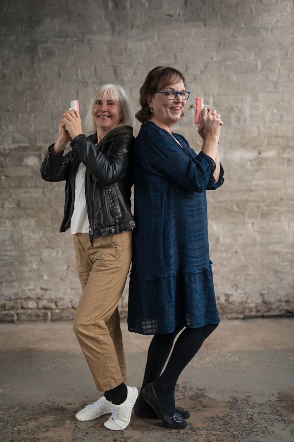 Vera Nentwich und Kerstin Rachfahl stehen Rücken an Rücken, jede mit einer pinken Spielzeugpistole